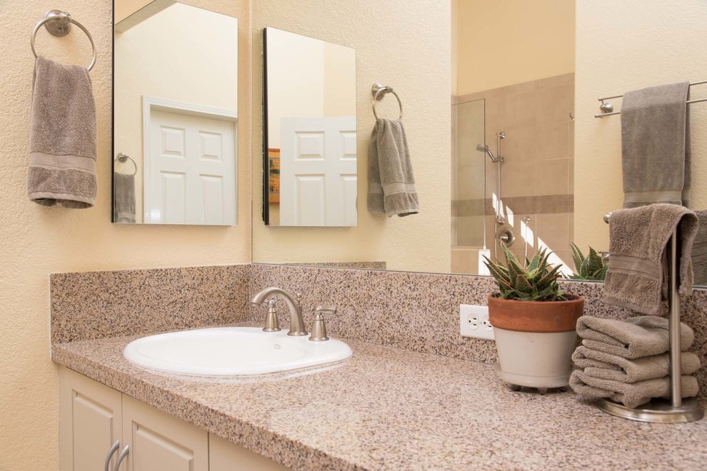 Bathroom - large contemporary master beige tile and porcelain tile porcelain tile bathroom idea in San Diego with an undermount sink, raised-panel cabinets, beige cabinets, granite countertops, a one-piece toilet and yellow walls