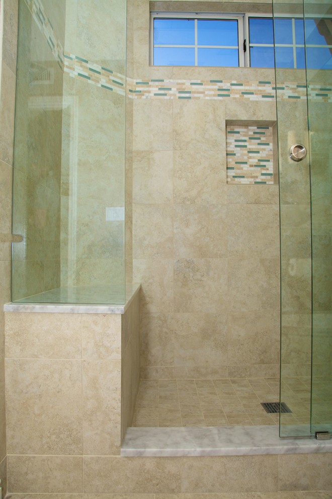 Photo of a medium sized classic shower room bathroom in San Diego with recessed-panel cabinets, medium wood cabinets, an alcove shower, a one-piece toilet, beige tiles, porcelain tiles, beige walls, porcelain flooring, a vessel sink, marble worktops, beige floors, a sliding door and white worktops.