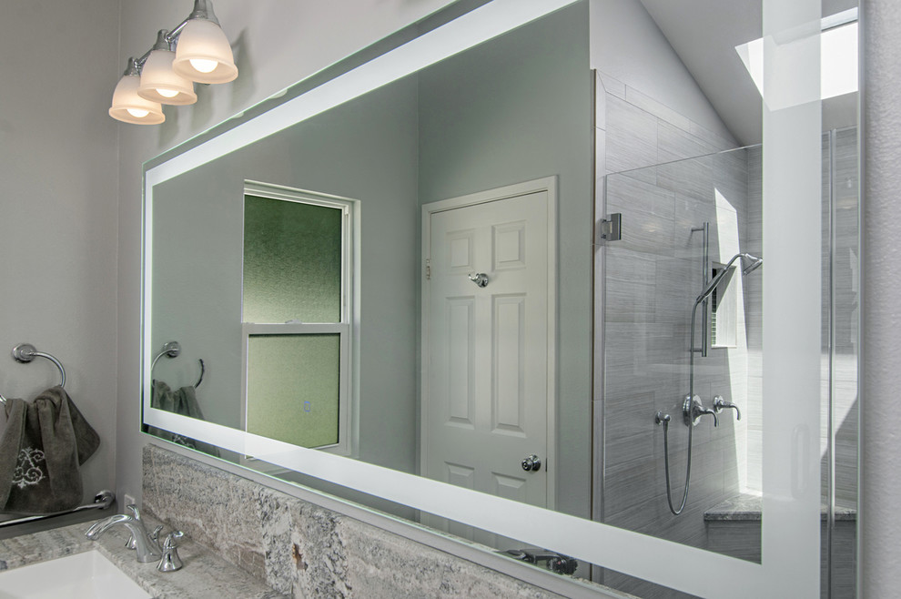 Пример оригинального дизайна: большая главная ванная комната в стиле модернизм с фасадами с утопленной филенкой, серыми фасадами, ванной в нише, открытым душем, раздельным унитазом, серой плиткой, керамогранитной плиткой, серыми стенами, полом из керамогранита, серым полом, душем с распашными дверями, врезной раковиной, столешницей из гранита, серой столешницей, тумбой под две раковины и встроенной тумбой