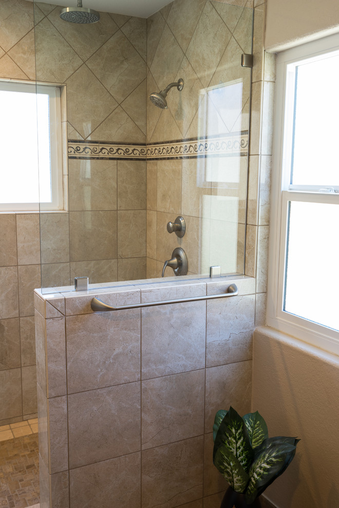 This is an example of a medium sized modern ensuite bathroom in San Diego with flat-panel cabinets, dark wood cabinets, solid surface worktops, a double shower, beige tiles, beige walls, ceramic flooring, a two-piece toilet, ceramic tiles and a built-in sink.