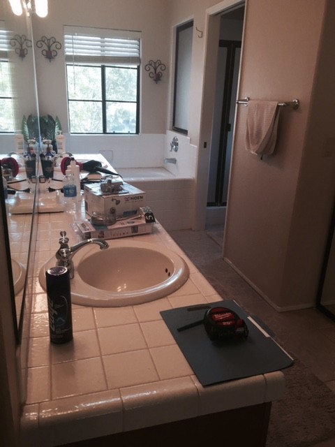 Medium sized modern ensuite bathroom in San Diego with flat-panel cabinets, dark wood cabinets, a double shower, a two-piece toilet, beige tiles, ceramic tiles, beige walls, ceramic flooring, a built-in sink and solid surface worktops.