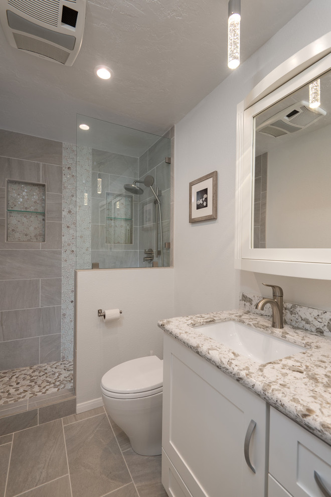 Design ideas for a large modern ensuite bathroom in San Diego with a submerged sink, shaker cabinets, white cabinets, engineered stone worktops, a walk-in shower, a one-piece toilet, grey tiles, porcelain tiles, white walls and porcelain flooring.