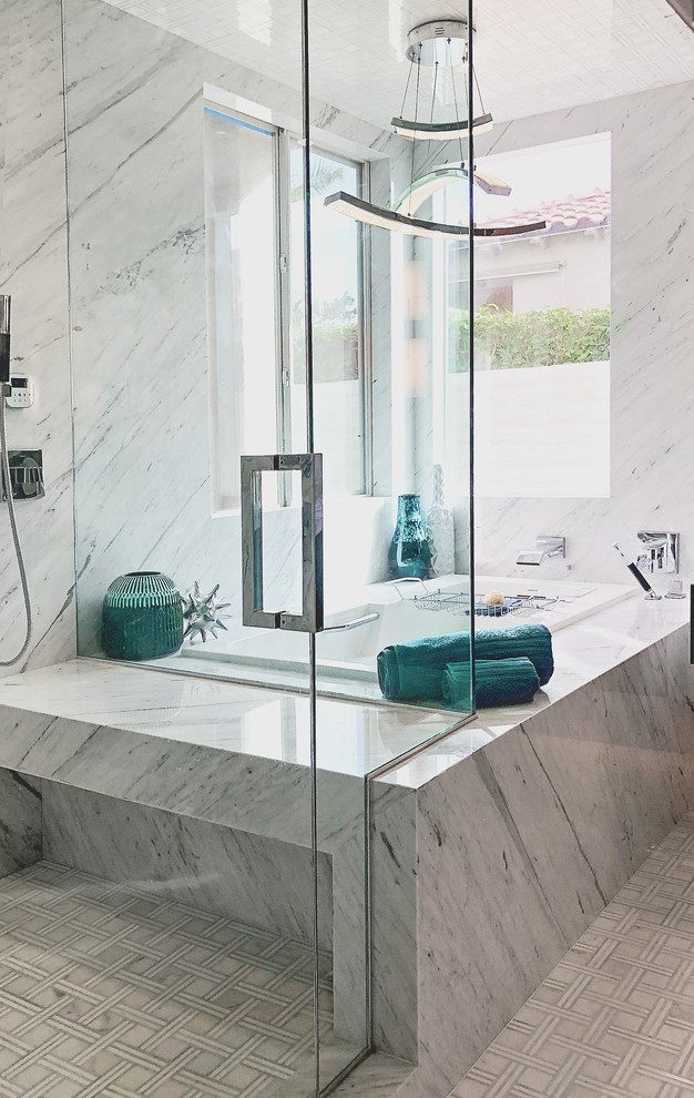 Medium sized contemporary ensuite bathroom in Los Angeles with flat-panel cabinets, dark wood cabinets, a built-in bath, a shower/bath combination, white tiles, marble tiles, grey walls, mosaic tile flooring, a vessel sink, marble worktops, white floors, a hinged door and white worktops.