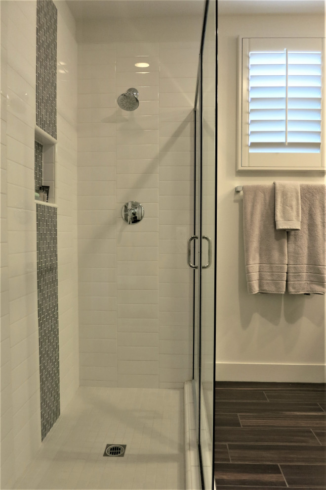 Свежая идея для дизайна: ванная комната среднего размера в современном стиле с угловым душем, белой плиткой, керамической плиткой, белыми стенами, полом из керамогранита, душевой кабиной, коричневым полом, душем с распашными дверями и нишей - отличное фото интерьера