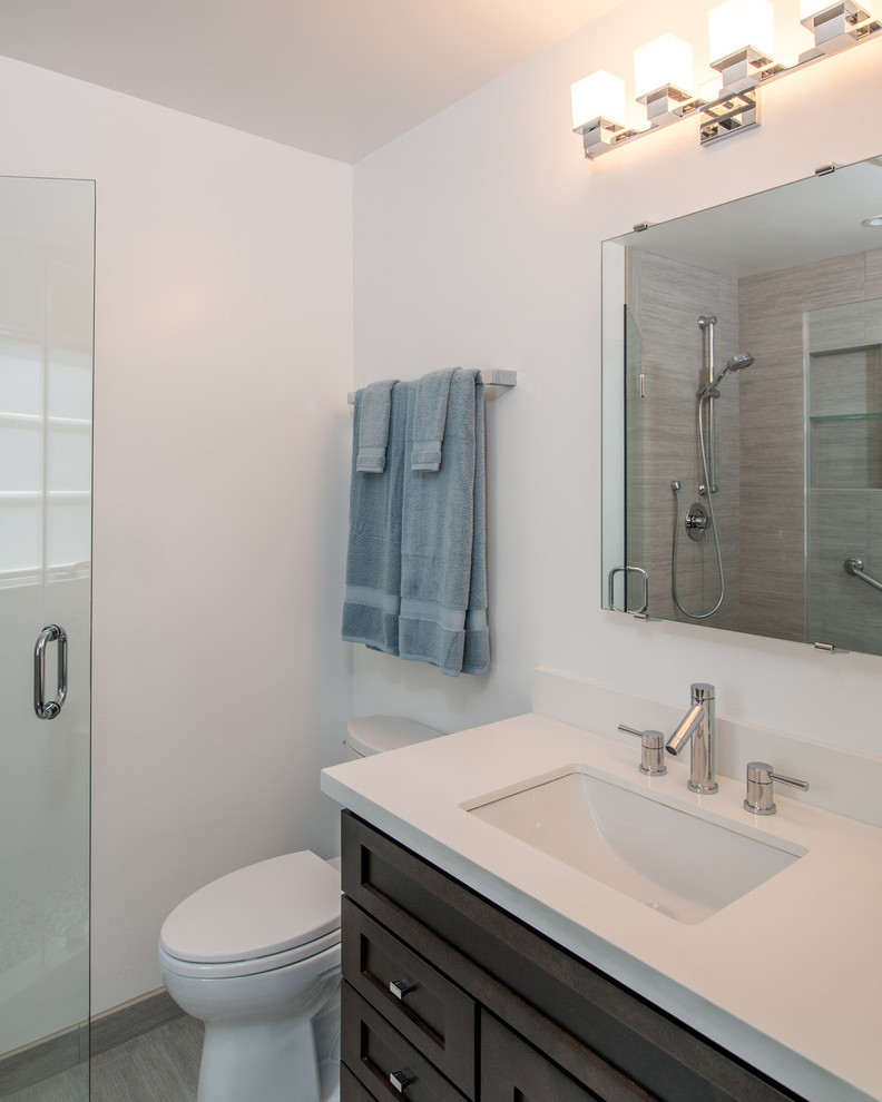 Photo of a medium sized modern shower room bathroom in San Diego with a submerged sink, recessed-panel cabinets, dark wood cabinets, an alcove shower, a one-piece toilet, grey tiles, ceramic tiles, white walls and ceramic flooring.