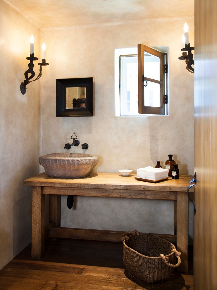 Diseño de cuarto de baño tradicional renovado con armarios abiertos, puertas de armario de madera clara, paredes beige, suelo de madera en tonos medios, lavabo sobreencimera y encimera de madera