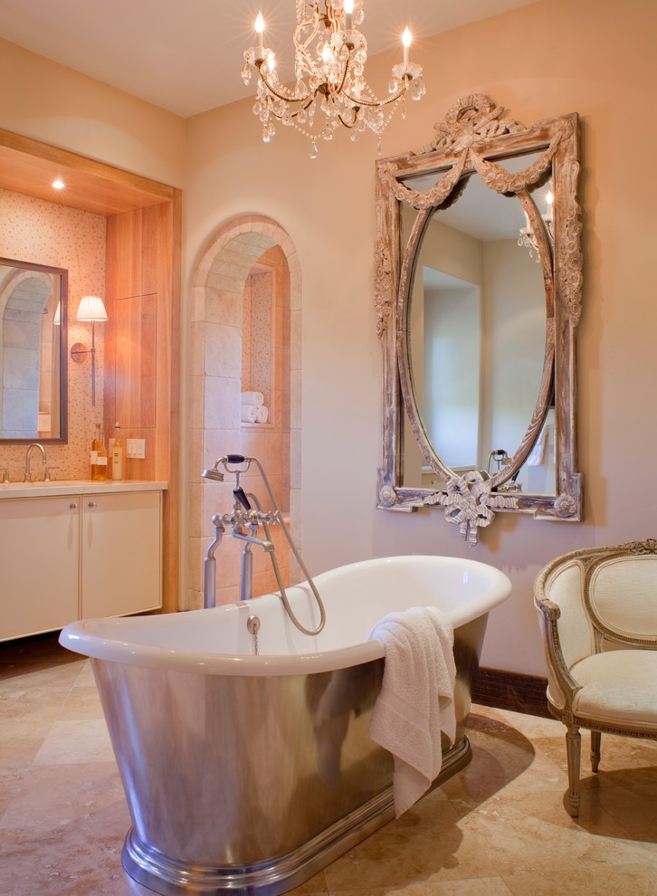 На фото: ванная комната в стиле шебби-шик с отдельно стоящей ванной и полом из травертина