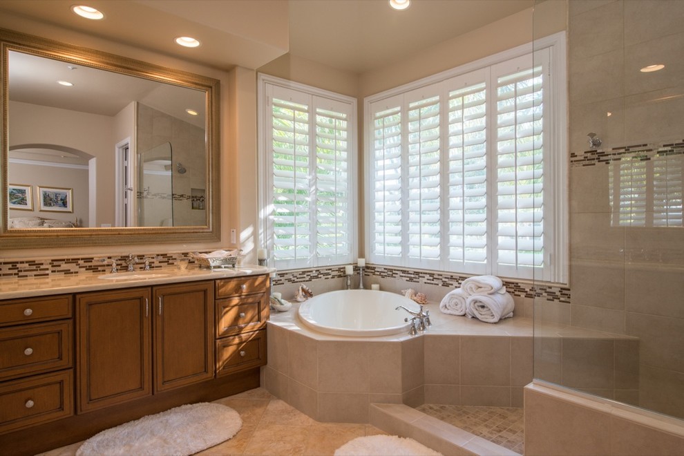 Immagine di una stanza da bagno classica con lavabo da incasso, ante lisce, ante in legno scuro, top in marmo, vasca ad alcova, doccia aperta, piastrelle multicolore e piastrelle in pietra