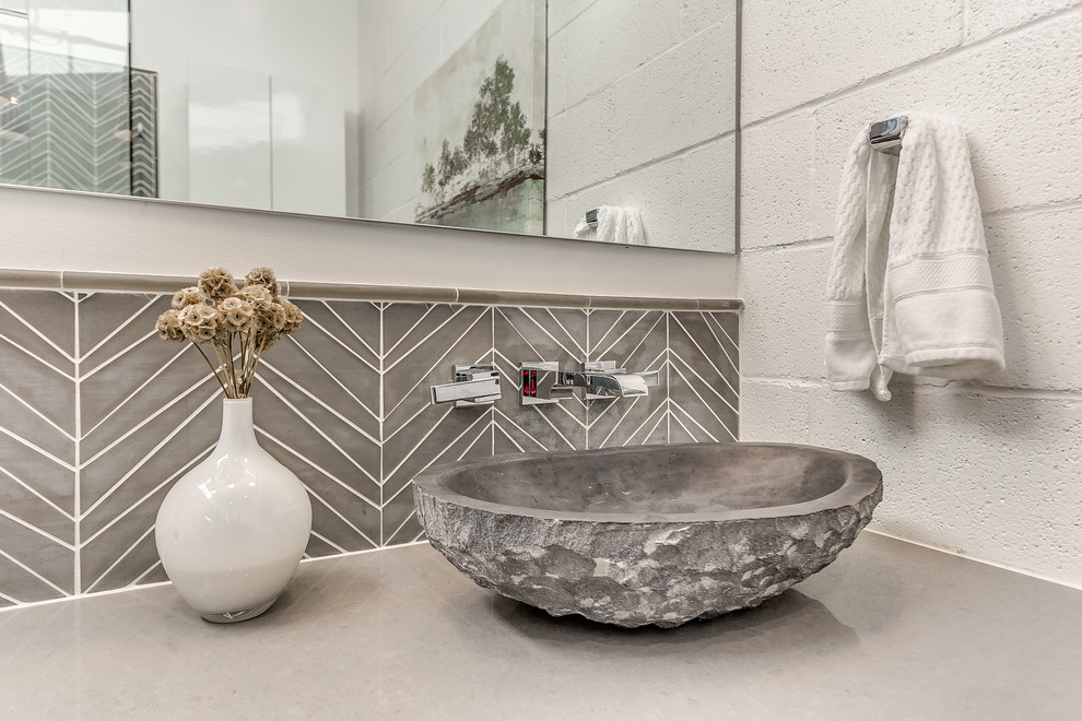 Modelo de cuarto de baño retro de tamaño medio con ducha esquinera, baldosas y/o azulejos grises, baldosas y/o azulejos de vidrio, suelo de cemento y aseo y ducha