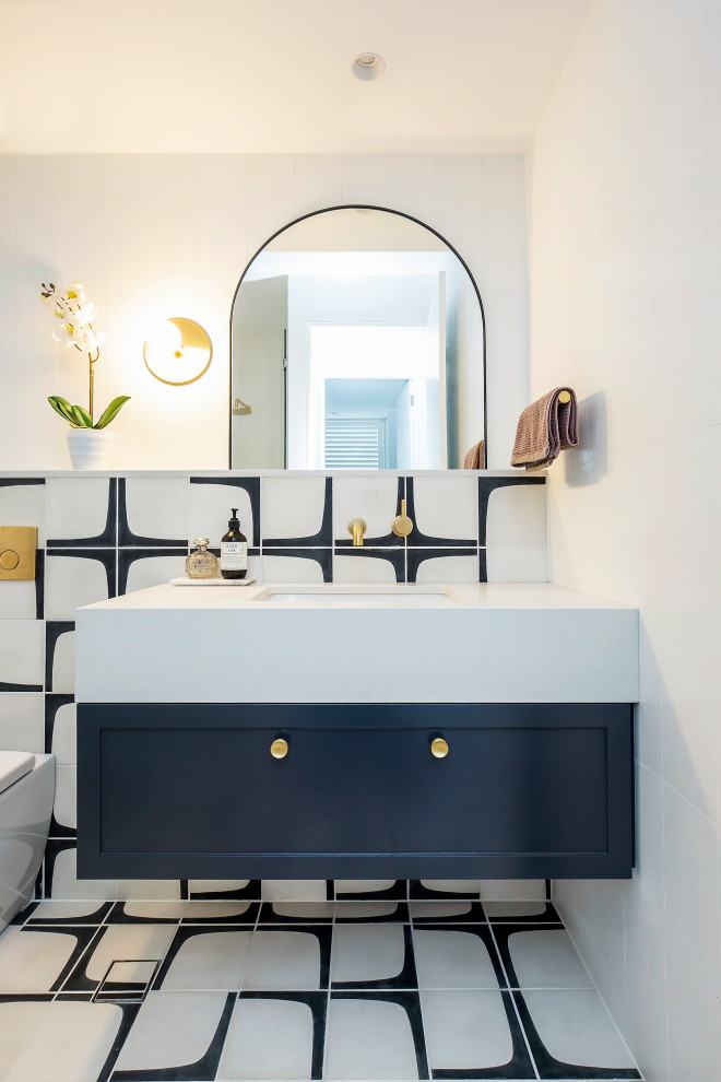 На фото: ванная комната в современном стиле с фасадами в стиле шейкер, синими фасадами, черно-белой плиткой, белыми стенами, врезной раковиной, разноцветным полом и белой столешницей