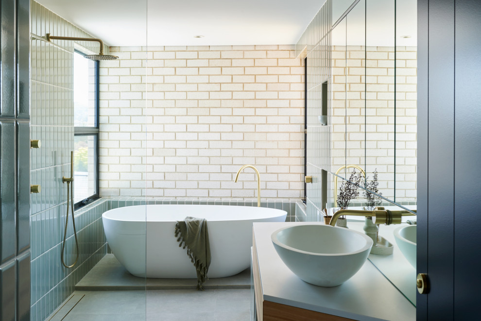 Design ideas for a medium sized contemporary ensuite wet room bathroom in Adelaide with medium wood cabinets, a freestanding bath, a one-piece toilet, green tiles, matchstick tiles, green walls, ceramic flooring, a vessel sink, engineered stone worktops, grey floors, an open shower, white worktops and flat-panel cabinets.