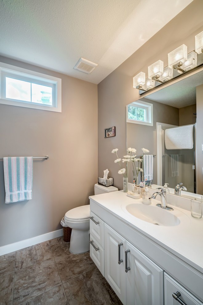 На фото: детская ванная комната среднего размера в стиле модернизм с фасадами в стиле шейкер, белыми фасадами, душем над ванной, унитазом-моноблоком, бежевыми стенами и накладной раковиной с