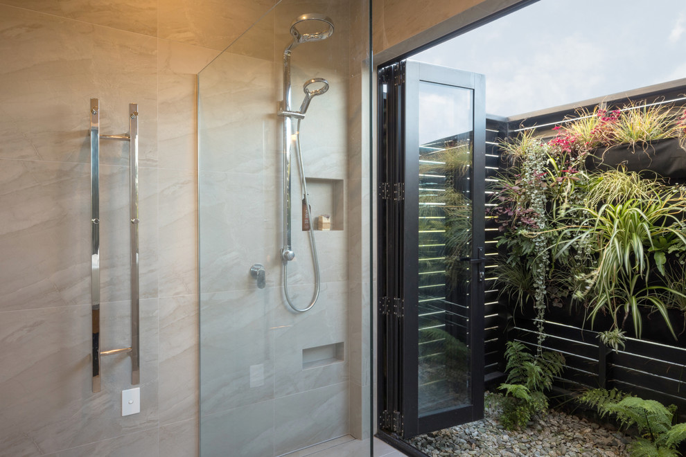 Photo of a medium sized contemporary ensuite wet room bathroom in Other with open cabinets, medium wood cabinets, a freestanding bath, a wall mounted toilet, grey tiles, ceramic tiles, grey walls, ceramic flooring, a vessel sink, wooden worktops, grey floors and an open shower.