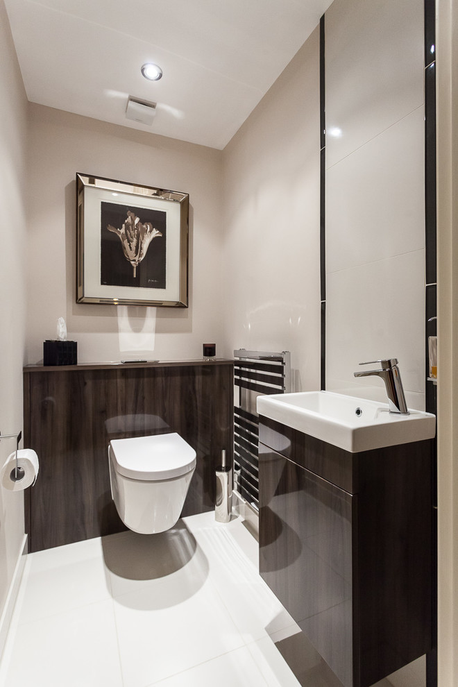 Design ideas for a medium sized classic cloakroom in Sussex with flat-panel cabinets, dark wood cabinets, a wall mounted toilet, a wall-mounted sink and white floors.