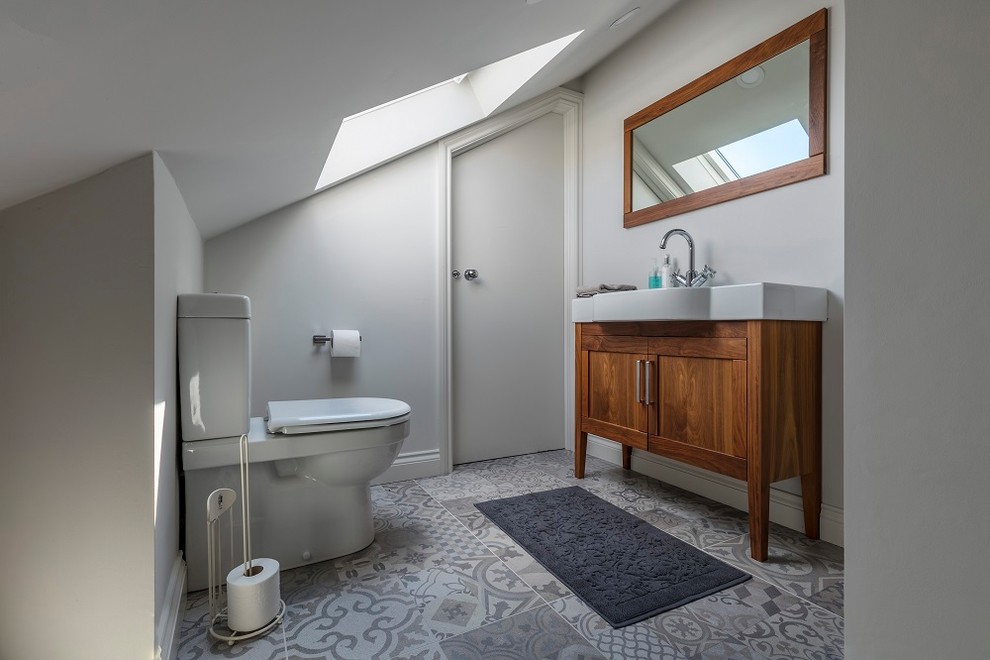 Immagine di una stanza da bagno design con ante in legno scuro
