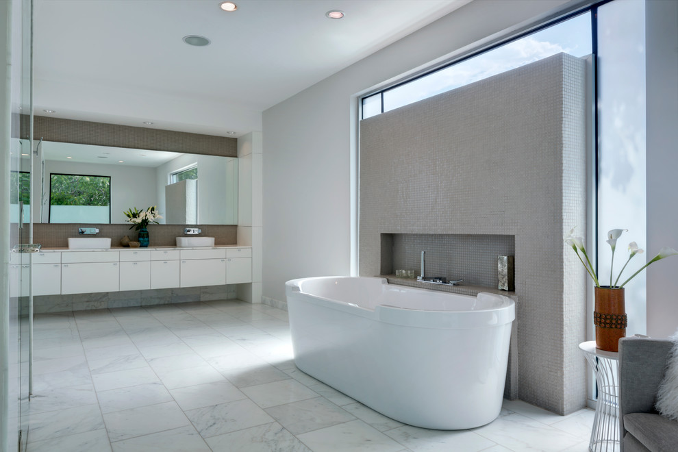 Modelo de cuarto de baño actual con lavabo sobreencimera, bañera exenta y baldosas y/o azulejos en mosaico