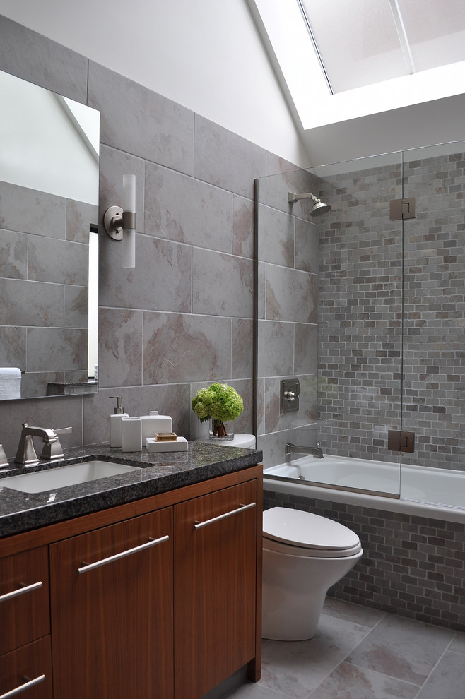 Trendy gray tile bathroom photo in Vancouver with an undermount sink, flat-panel cabinets and dark wood cabinets