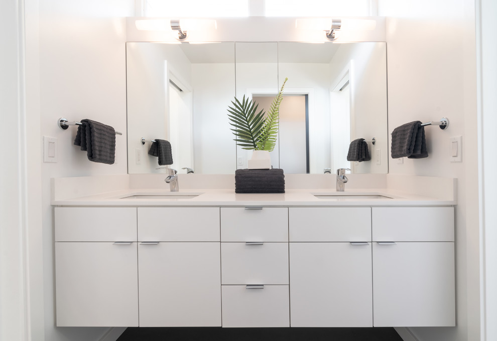 This is an example of a medium sized modern family bathroom in Seattle with flat-panel cabinets, white cabinets, an alcove shower, a two-piece toilet, white tiles, ceramic tiles, white walls, ceramic flooring, a submerged sink, solid surface worktops, grey floors, a hinged door and white worktops.