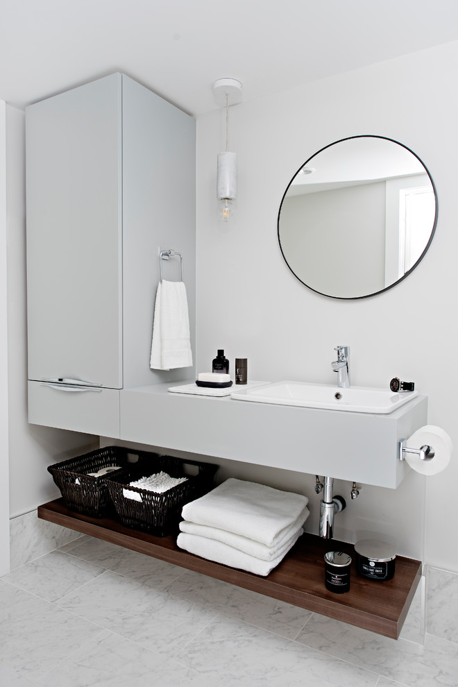 Exemple d'une petite salle d'eau tendance avec un placard à porte plane, des portes de placard grises, un mur blanc, un sol en carrelage de porcelaine, un plan de toilette en surface solide, un plan de toilette gris, un lavabo posé et un sol gris.
