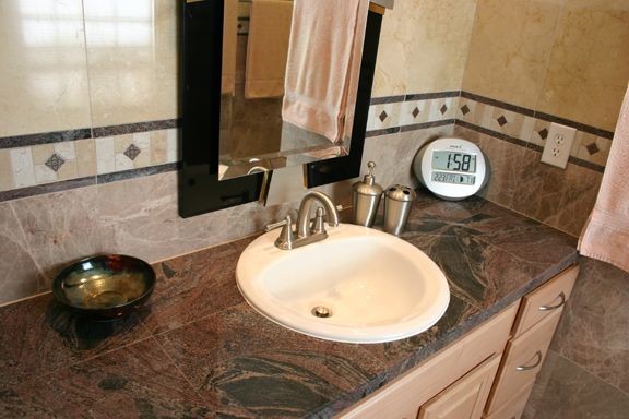 Idéer för ett mellanstort klassiskt badrum med dusch, med luckor med upphöjd panel, skåp i ljust trä, en kantlös dusch, beige kakel, beige väggar, ett nedsänkt handfat, en toalettstol med separat cisternkåpa och granitbänkskiva