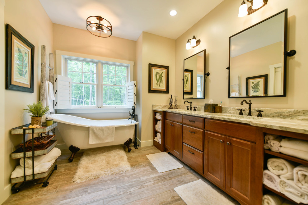 Photo of a medium sized classic ensuite bathroom in Portland Maine with recessed-panel cabinets, dark wood cabinets, a claw-foot bath, a corner shower, a one-piece toilet, multi-coloured tiles, slate tiles, grey walls, ceramic flooring, a submerged sink, granite worktops, beige floors and a hinged door.