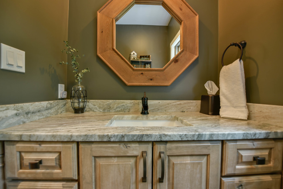 Kleines Rustikales Badezimmer mit profilierten Schrankfronten, hellen Holzschränken, grüner Wandfarbe, braunem Holzboden, Granit-Waschbecken/Waschtisch und braunem Boden in Portland Maine