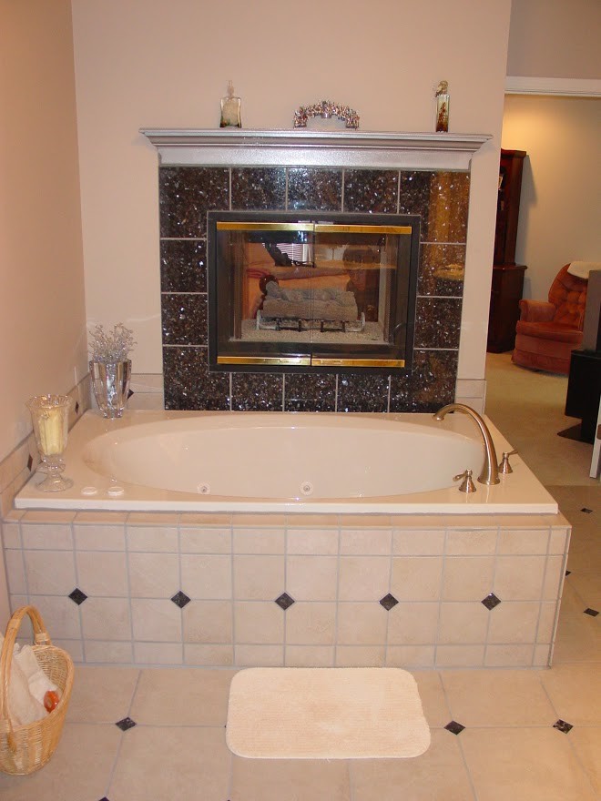 Cette photo montre une grande salle de bain principale chic avec une baignoire posée, un carrelage beige, des carreaux de porcelaine et un sol en carrelage de porcelaine.
