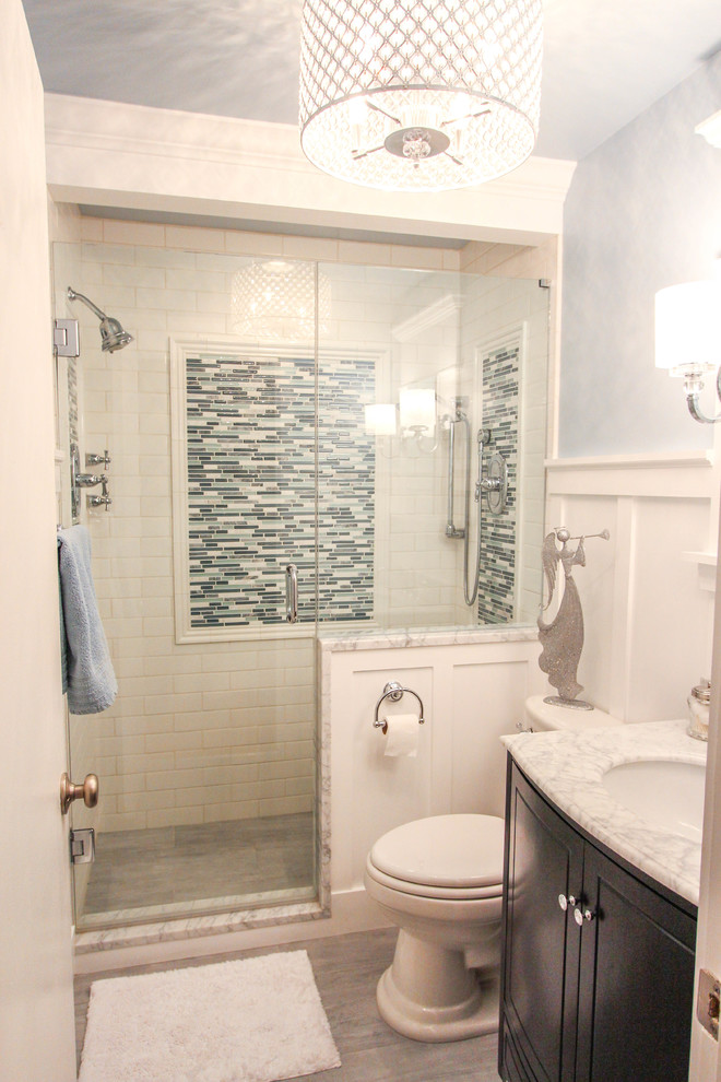 Small traditional shower room bathroom in Cincinnati with a submerged sink, raised-panel cabinets, dark wood cabinets, marble worktops, a double shower, a two-piece toilet, white tiles, metro tiles, blue walls and travertine flooring.