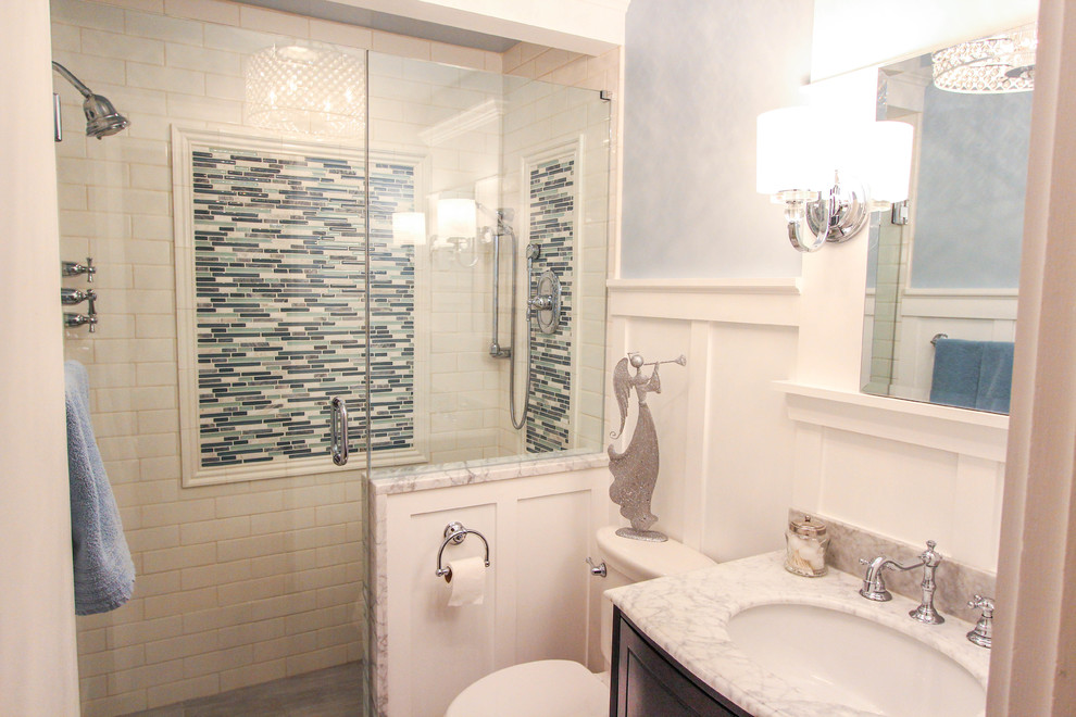 Aménagement d'une petite salle d'eau classique en bois foncé avec un lavabo encastré, un placard avec porte à panneau surélevé, un plan de toilette en marbre, une douche double, WC séparés, un carrelage blanc, un carrelage métro, un mur bleu et un sol en travertin.