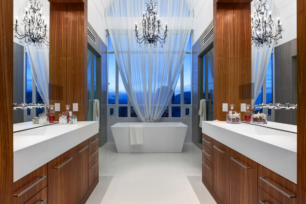 Свежая идея для дизайна: главная ванная комната в современном стиле с монолитной раковиной, плоскими фасадами, фасадами цвета дерева среднего тона, отдельно стоящей ванной и окном - отличное фото интерьера