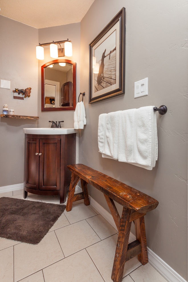 Kleines Uriges Badezimmer mit Sockelwaschbecken, verzierten Schränken, dunklen Holzschränken, beigen Fliesen, Keramikfliesen, grauer Wandfarbe und Keramikboden in Sonstige