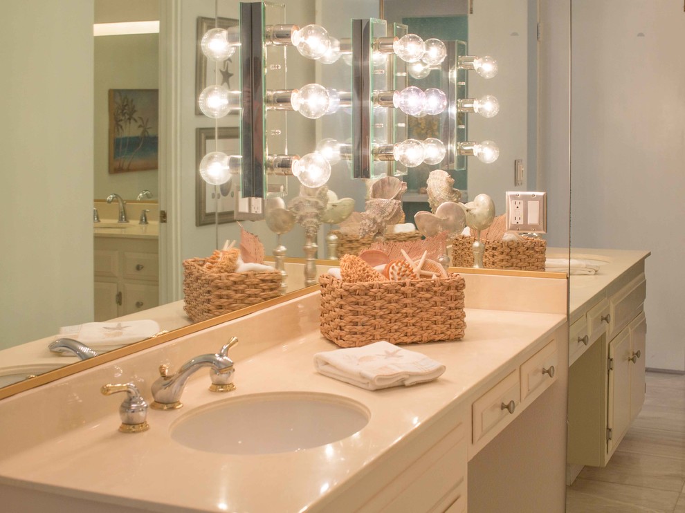 This is an example of a medium sized coastal bathroom in Los Angeles with raised-panel cabinets, white cabinets, white walls and porcelain flooring.