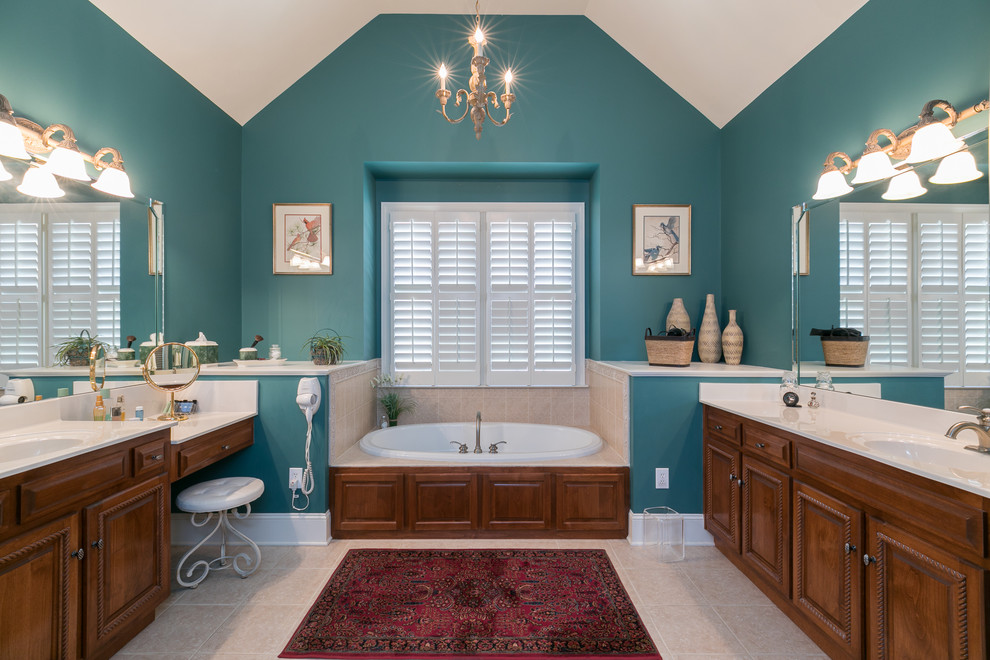 Foto de cuarto de baño clásico con armarios con paneles con relieve, puertas de armario de madera en tonos medios, baldosas y/o azulejos beige, paredes azules y suelo beige