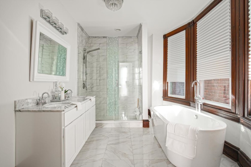 Photo of a medium sized contemporary ensuite bathroom in Philadelphia with shaker cabinets, white cabinets, a freestanding bath, an alcove shower, grey walls, porcelain flooring, a submerged sink, marble worktops, grey floors and a hinged door.