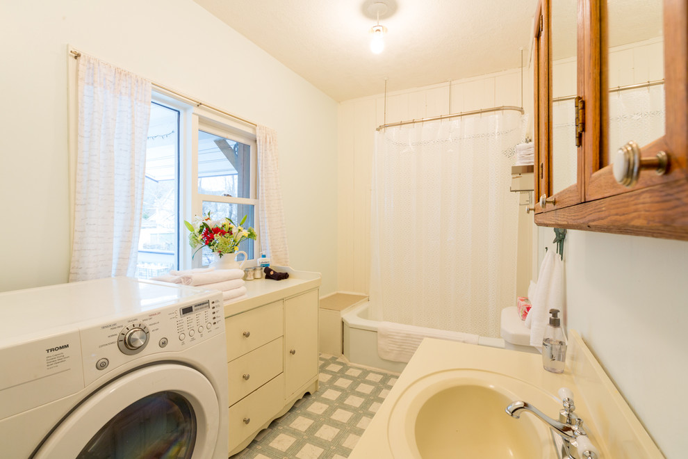 Kleines Klassisches Badezimmer En Suite mit Eckbadewanne, Duschbadewanne, grauer Wandfarbe, integriertem Waschbecken, Laminat-Waschtisch, grauem Boden, Duschvorhang-Duschabtrennung, beiger Waschtischplatte und Wäscheaufbewahrung in Vancouver