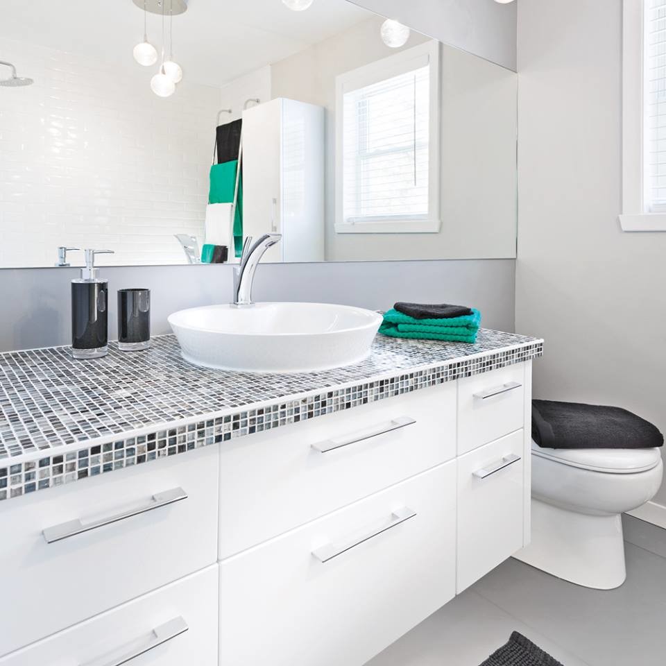 Exemple d'une salle de bain tendance de taille moyenne avec un lavabo intégré, un plan de toilette en carrelage et des plaques de verre.