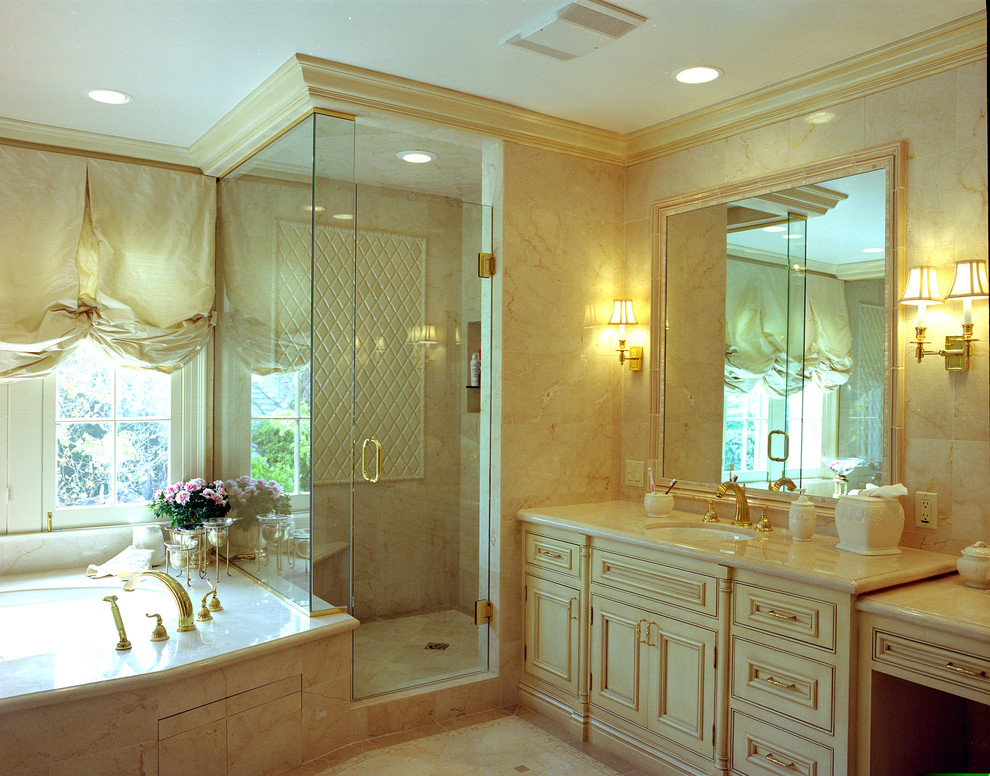 Immagine di una stanza da bagno classica con lavabo sottopiano, ante beige, doccia ad angolo e piastrelle beige
