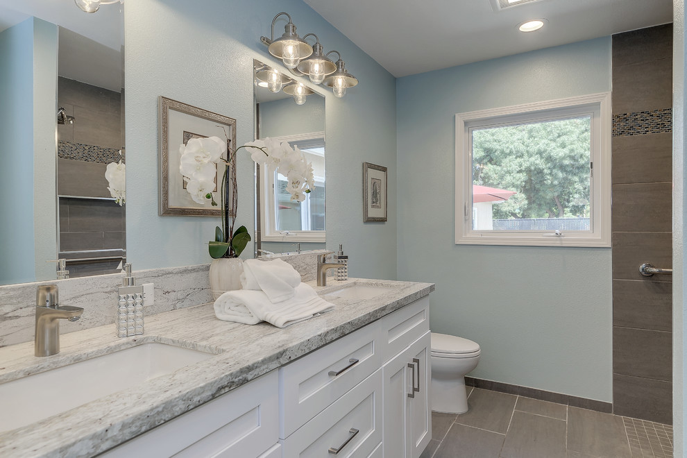 Inredning av ett klassiskt mellanstort grå grått badrum med dusch, med skåp i shakerstil, vita skåp, en kantlös dusch, en toalettstol med separat cisternkåpa, brun kakel, blå väggar och ett undermonterad handfat