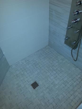 Cette image montre une salle de bain principale avec une douche d'angle, un carrelage multicolore et un sol en carrelage de porcelaine.