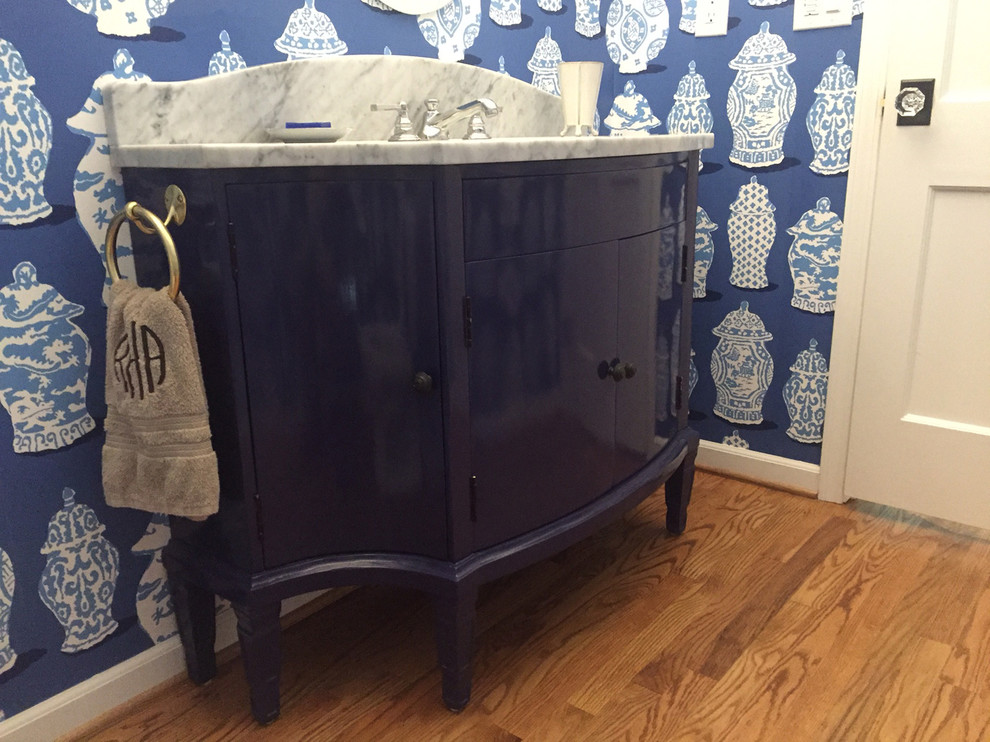 Exempel på ett mellanstort medelhavsstil badrum, med möbel-liknande, blå skåp, blå väggar, mellanmörkt trägolv, ett undermonterad handfat, marmorbänkskiva och brunt golv