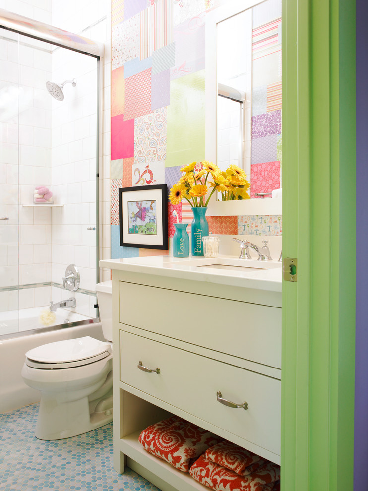 Cette image montre une salle de bain bohème de taille moyenne pour enfant avec des portes de placard blanches, un placard à porte plane, une baignoire en alcôve, un combiné douche/baignoire, WC séparés, un carrelage gris, un carrelage multicolore, un carrelage blanc, des carreaux de porcelaine, un mur multicolore, un lavabo encastré, un plan de toilette en surface solide, un sol en carrelage de terre cuite et un plan de toilette blanc.