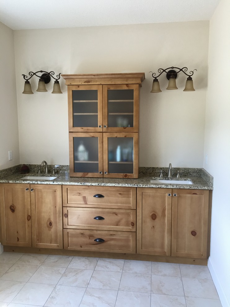 Mountain style master porcelain tile bathroom photo in Jacksonville with shaker cabinets, medium tone wood cabinets, beige walls, an undermount sink and granite countertops