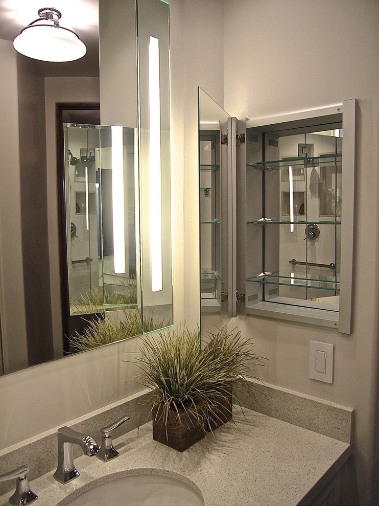 Modelo de cuarto de baño tradicional renovado de tamaño medio con armarios con paneles empotrados, puertas de armario grises, encimera de cuarzo compacto y aseo y ducha