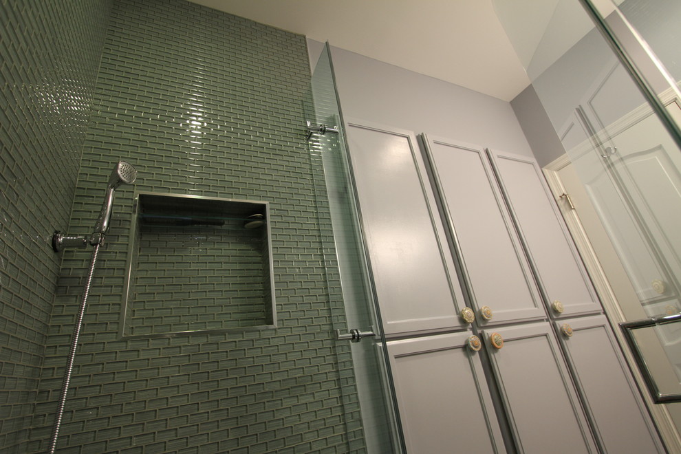Klassisk inredning av ett litet badrum, med ett undermonterad handfat, luckor med infälld panel, grå skåp, bänkskiva i kvarts, en dusch i en alkov, en toalettstol med hel cisternkåpa, grön kakel, glaskakel, grå väggar och klinkergolv i porslin