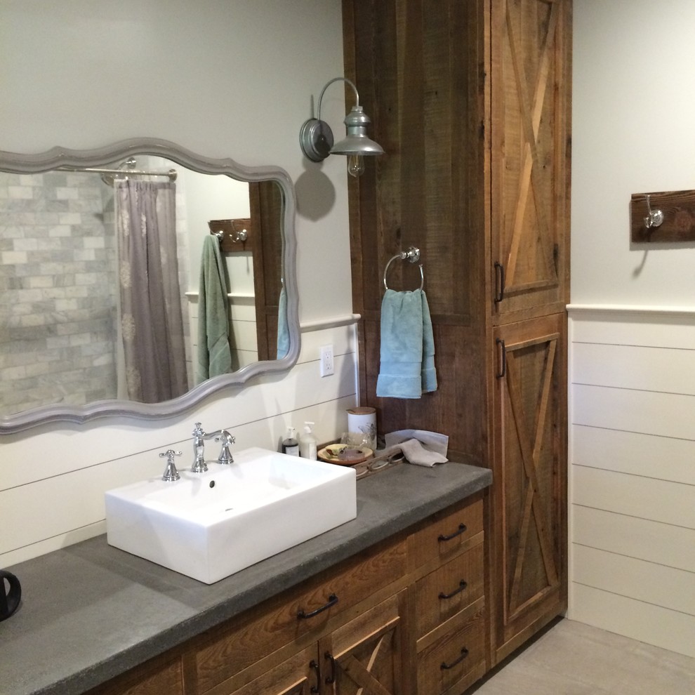 Bild på ett litet amerikanskt badrum med dusch, med luckor med upphöjd panel, skåp i slitet trä, ett platsbyggt badkar, en öppen dusch, en toalettstol med separat cisternkåpa, grå kakel, keramikplattor, vita väggar, klinkergolv i keramik, ett konsol handfat, bänkskiva i betong, beiget golv och dusch med duschdraperi