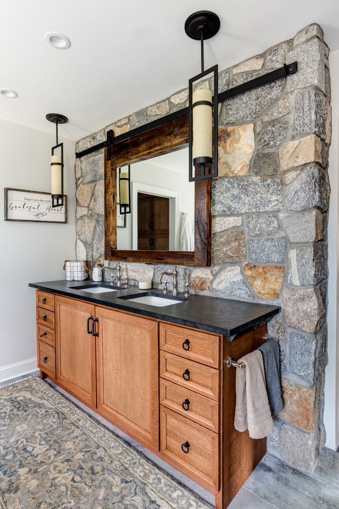 Large rustic ensuite bathroom in New York with shaker cabinets, light wood cabinets, a walk-in shower, a one-piece toilet, grey tiles, cement tiles, grey walls, cement flooring, a submerged sink, granite worktops, grey floors, a sliding door and a claw-foot bath.