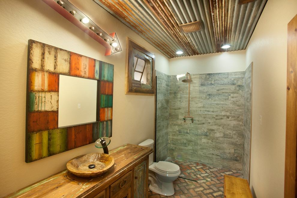 Inredning av ett rustikt badrum, med en kantlös dusch, träbänkskiva och tegelgolv