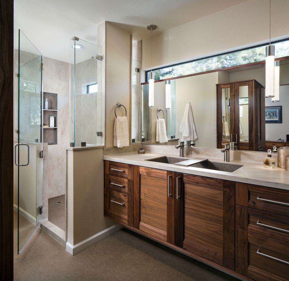 Klassisk inredning av ett en-suite badrum, med ett avlångt handfat, luckor med infälld panel, skåp i mellenmörkt trä, bänkskiva i akrylsten, en öppen dusch, en toalettstol med hel cisternkåpa och linoleumgolv