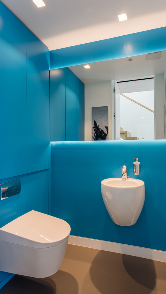 Ejemplo de cuarto de baño contemporáneo pequeño con armarios con paneles lisos, puertas de armario azules, baldosas y/o azulejos azules y encimera de madera