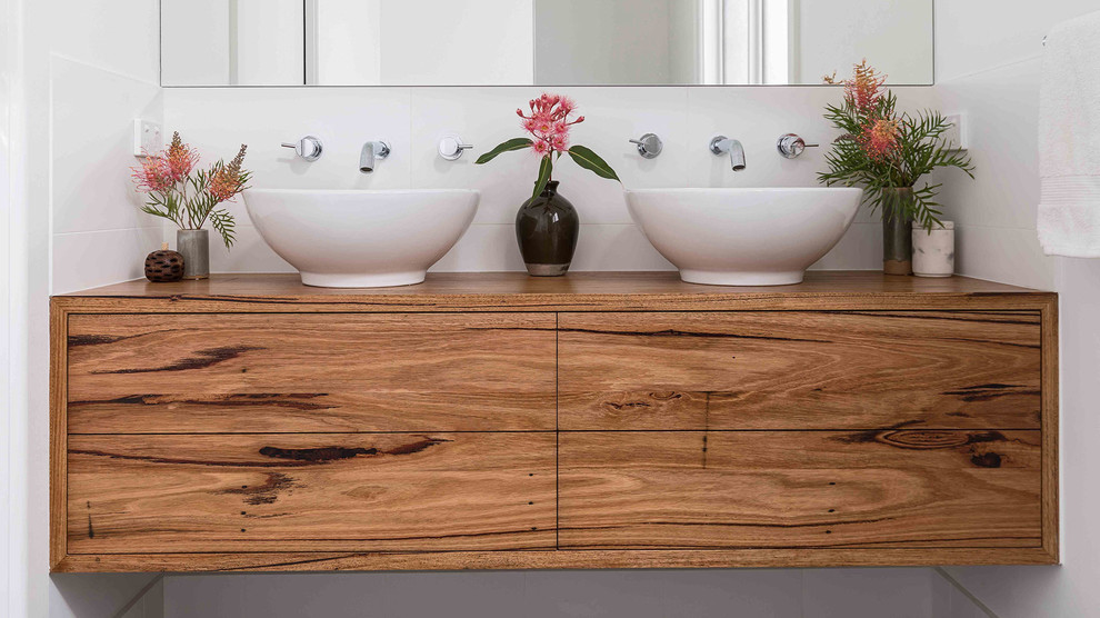 Modernes Badezimmer mit hellbraunen Holzschränken, weißen Fliesen, Keramikfliesen, weißer Wandfarbe, Schieferboden, Aufsatzwaschbecken, Waschtisch aus Holz und grauem Boden in Melbourne